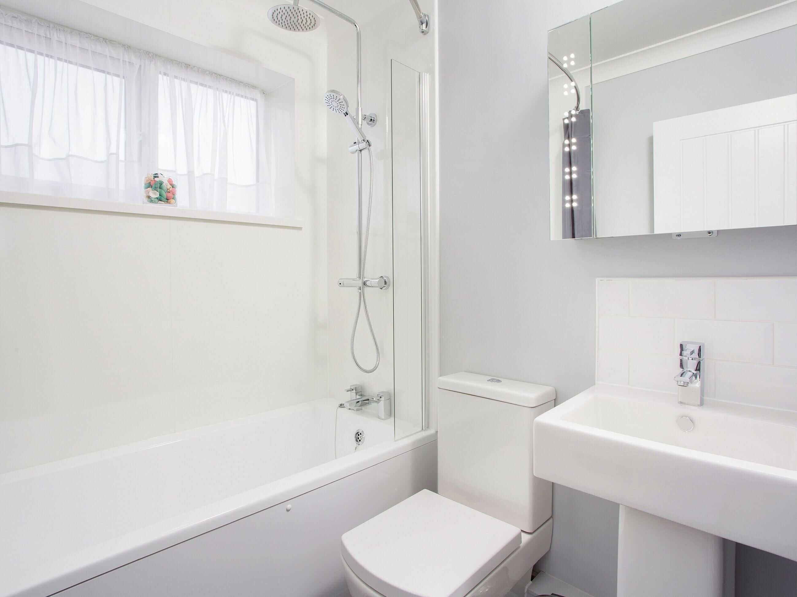 A modern bathroom with a bathtub, toilet, and sink.