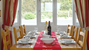 A dining table set for six with wine glasses, plates, and a bottle of wine. - 2 bedroom accommodation in Freshwater East near Pembroke (Freshwater East near Pembroke)