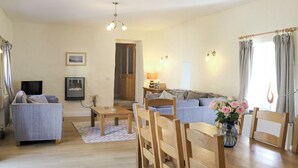 Un salon avec un canapé, une table basse et un téléviseur.
