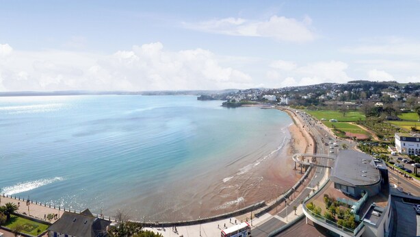 A coastal town with a beach, a promenade, and residential areas.
