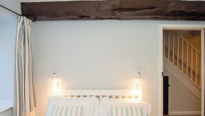 A bedroom with a white bed, striped pillows, and two bedside lamps. - Number Seven - UKC4969 (Tawstock, near Barnstaple)