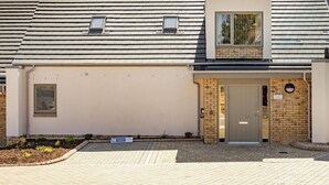 A building with a flat roof, a small window, and a door with a sign above it. - Largo Lodge - UKC5801 (Lundin Links)