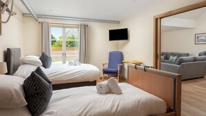 A hotel room with two beds, a TV, a desk, and a view of the outdoors. - Largo Lodge - UKC5801 (Lundin Links)