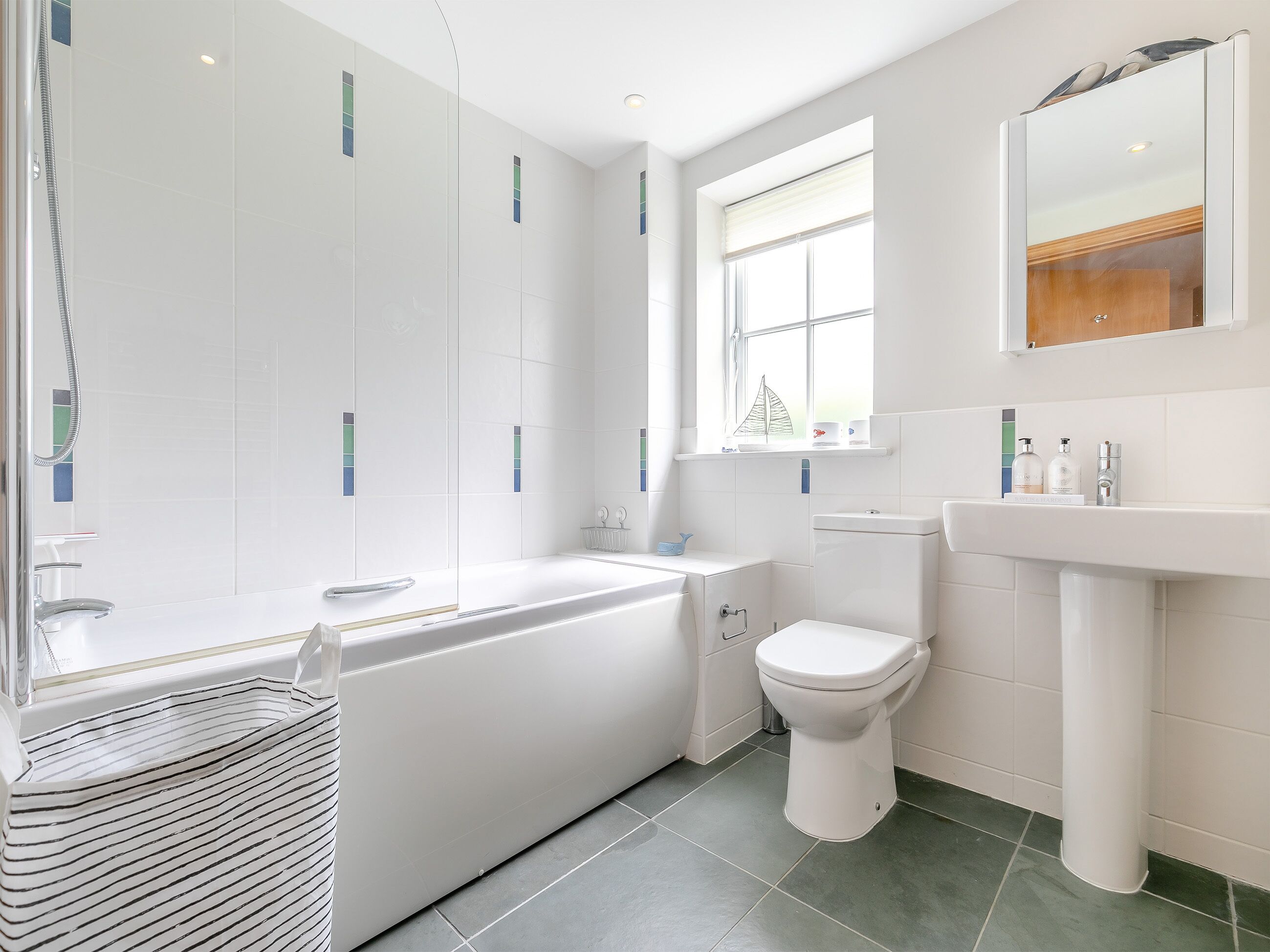 Ein modernes Badezimmer mit Badewanne, Toilette und Waschbecken.
