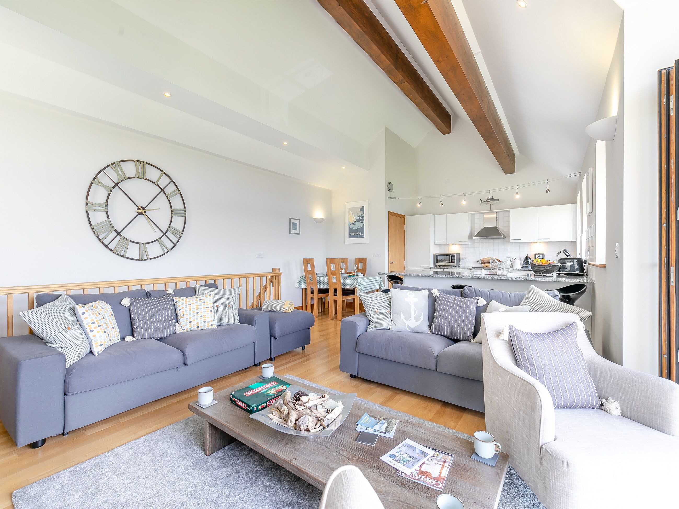 A modern living room with two sofas, a coffee table, and a dining area with a table and chairs.