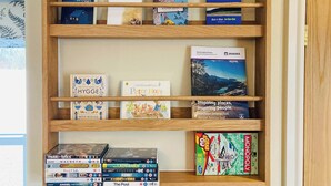 Ein Bücherregal mit verschiedenen Büchern und Gesellschaftsspielen.