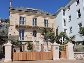 A two-story building with a stone facade, a balcony, and a gated entrance. - 2 bedroom accommodation in Ventnor (Ventnor)