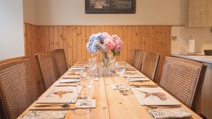 Una tavola imbandita con sedie, un vaso di fiori e un quadro appeso al muro.