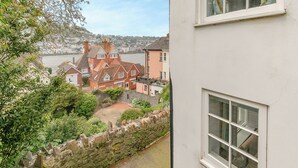 Een uitzicht op een kustplaatsje met traditionele architectuur, een stenen muur en een rivier.