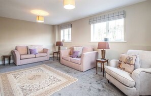 A spacious living room with two sofas, a coffee table, and a patterned rug. - 4 bedroom accommodation in Thorpeness (Thorpeness)