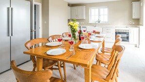 Comedor con mesa de madera dispuesta para seis personas, rodeado de sillas.