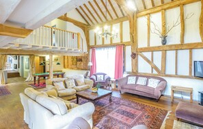 A spacious living area with a high ceiling, wooden beams, a billiards table, multiple sofas, and a large window with curtains. - 7 bedroom accommodation in Darsham, near Saxmundham (Darsham, near Saxmundham)