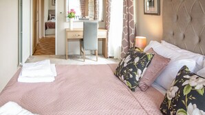 Una habitación de hotel con cama, escritorio y espejo.
