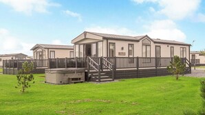 Une rangée de maisons mobiles, avec une cour gazonnée et une clôture en bois.