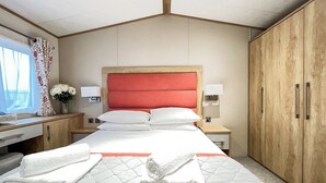 Una camera d'albergo con un letto, comodini, una scrivania e un armadio.