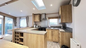 Una cucina con mobili in legno, un'isola centrale, un lucernario e vista sull'esterno.