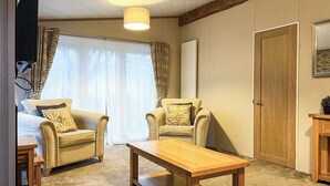 Une pièce confortable avec deux fauteuils, une table en bois et un lit.