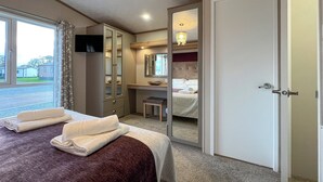 A bedroom with a bed, a wardrobe, a desk, and a mirror. - 2 bedroom accommodation in St Andrews (St Andrews)