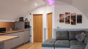 Eine moderne Küche mit Holzarbeitsplatte, Einbauofen und Essbereich mit grauem Sofa.