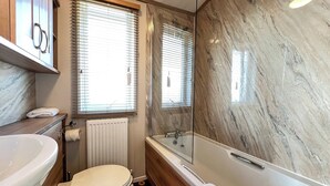 Ein Badezimmer mit Badewanne, Toilette und Waschbecken.
