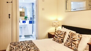 A bedroom with a bed, pillows, a nightstand, a lamp, and a mirror. - 3 bedroom accommodation in Wooton Fitzpaine, near Charmouth (Wooton Fitzpaine, near Charmouth)