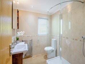 A modern bathroom with a glass shower enclosure, a white toilet, and a sink with a towel rack. - 2 bedroom accommodation in Glanrafon Uchaf (Glanrafon Uchaf)