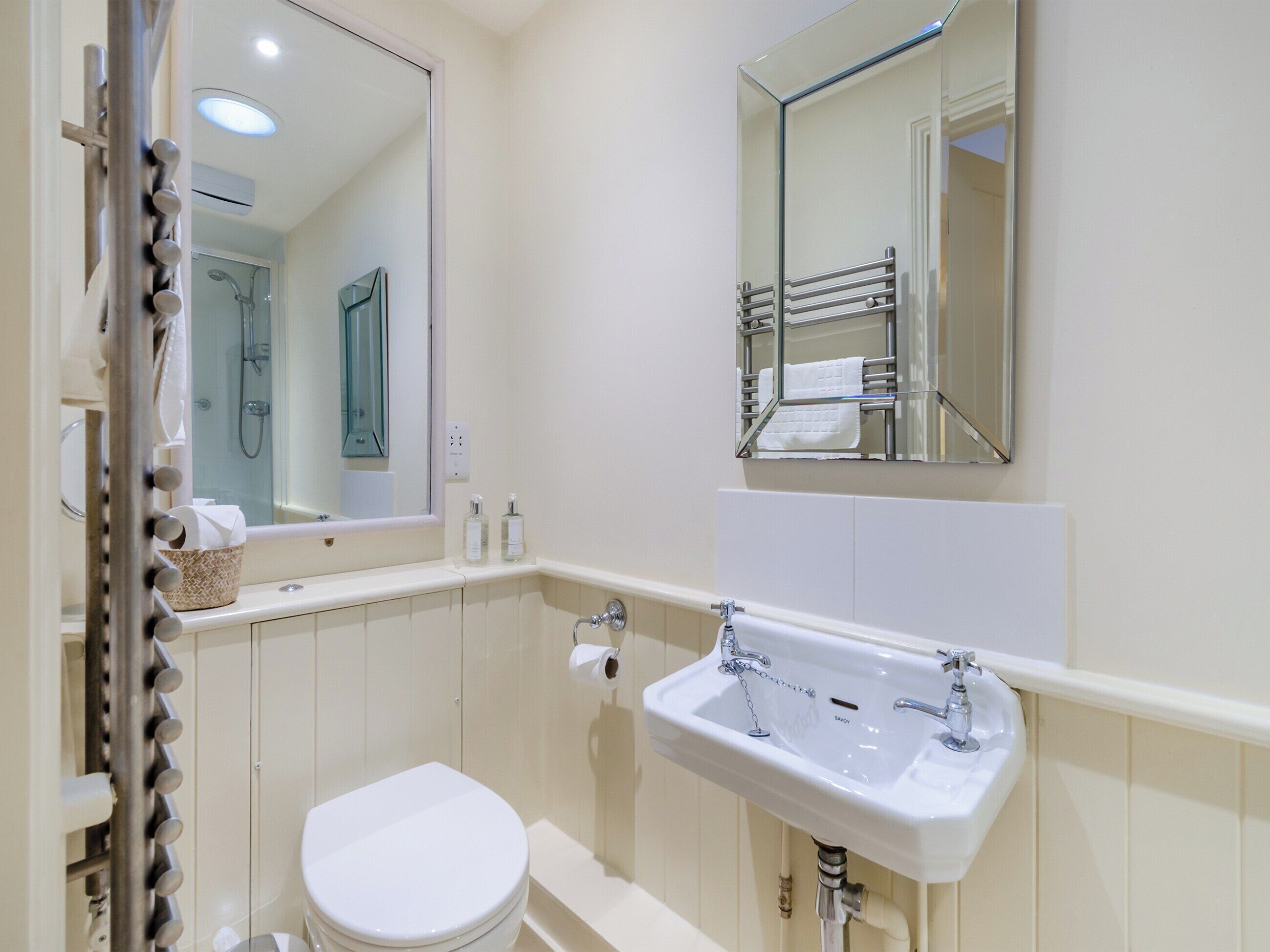 Un baño moderno con inodoro blanco, lavabo y ducha.