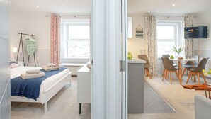 Een moderne hotelkamer met een bed, een bureau en een zithoek.
