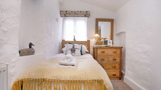 A bedroom with a bed, wooden dresser, and a window with curtains. - Jasmine Cottage - UKC6179 (Marldon, near Paignton)