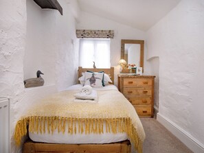 A bedroom with a bed, wooden dresser, and a window with curtains. - Jasmine Cottage - UKC6179 (Marldon, near Paignton)