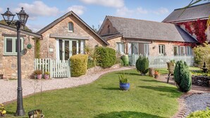 A stone building with a white picket fence, a well-maintained lawn, and a street lamp. - Jasmine Cottage - UKC6179 (Marldon, near Paignton)