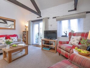 A living room with a sofa, a coffee table, a television, and a bookshelf. - Rose Cottage - UKC6181 (Marldon, near Paignton)