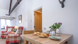 Ein Essbereich mit Holztisch, Stühlen und einem an der Wand befestigten Hirschkopf.