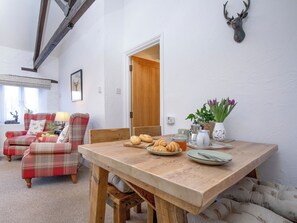 A dining area with a wooden table, chairs, and a wall-mounted deer head. - Rose Cottage - UKC6181 (Marldon, near Paignton)