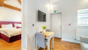 A hotel room with a bed, a desk with a chair, a TV, and a window. - 1 bedroom accommodation in Low Hunsley, Cottingham (Low Hunsley, Cottingham)
