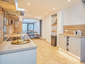 A modern kitchen with a central island, built-in appliances, and a view to the outdoors. - 3 bedroom accommodation in Cowes (Cowes)