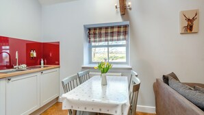 Una cocina con una mesa de comedor, sillas y una ventana con vistas.