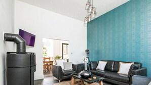 Een moderne woonkamer met een zwarte bank, een salontafel en een open haard.
