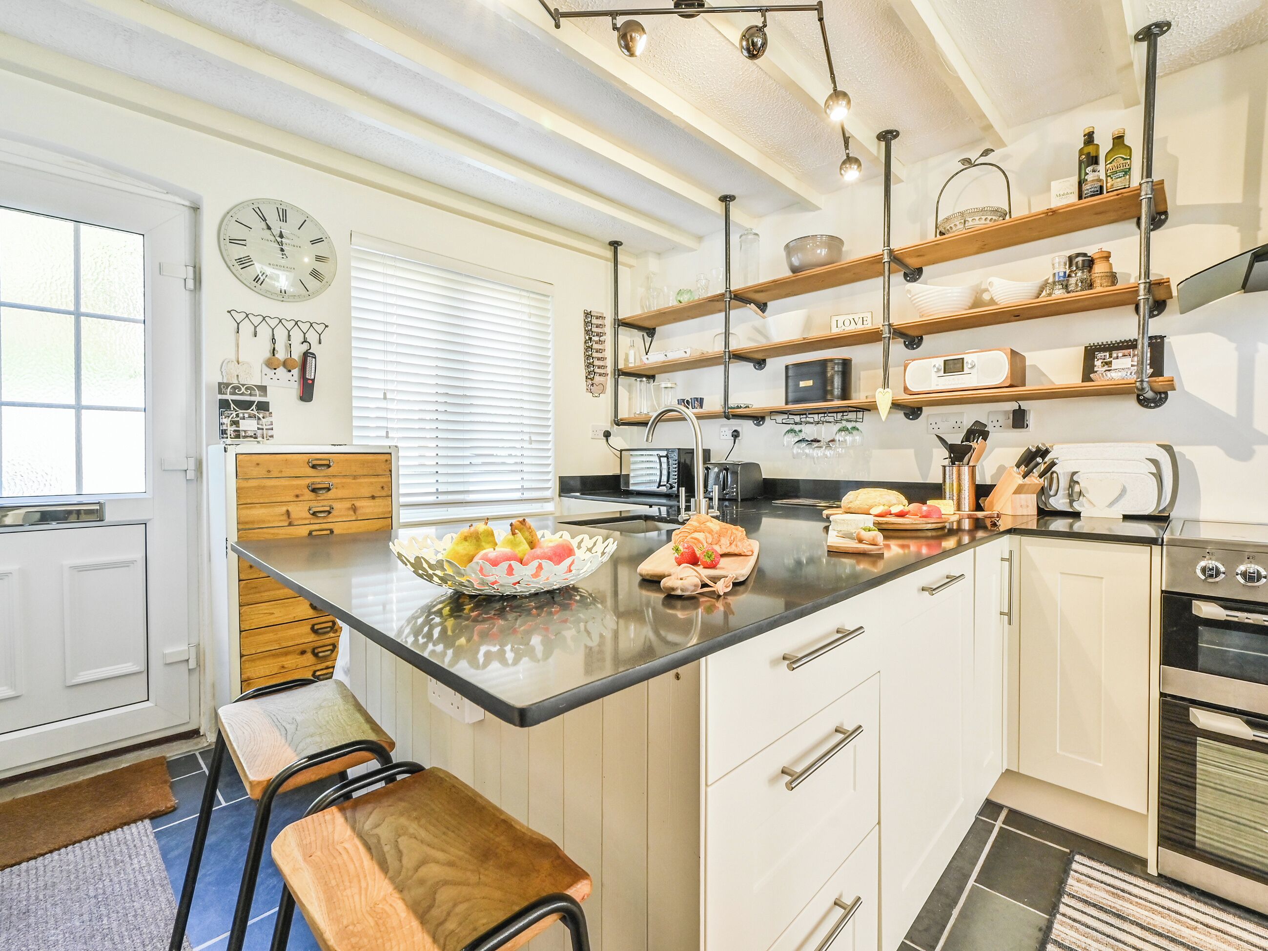 A modern kitchen with a central island, wooden cabinets, and built-in appliances.