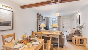Ein gemütliches Wohnzimmer mit Essbereich, Holzmöbeln, einem Kamin und Blick auf die Stadt.