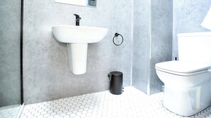 Ein modernes Badezimmer mit Waschbecken, Toilette und Duschbereich.