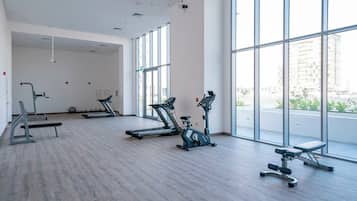 Un gimnasio con cintas de correr, elípticas y bancos de pesas.