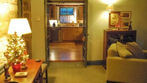 A cozy living room with a fireplace, a dining table with a Christmas tree, and a kitchen in the background. - 5 bedroom accommodation in Over Haddon, near Bakewell (Over Haddon, near Bakewell)