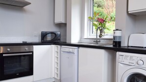 A modern kitchen with a microwave, oven, dishwasher, and washing machine.