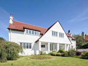 A two-story white house with a red-tiled roof, multiple windows, and a well-maintained garden. - 2 bedroom accommodation in Troon, near Ayr (Troon, near Ayr)