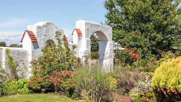 A garden with white stone structures, a stone pathway, and various plants. - 2 bedroom accommodation in Troon, near Ayr (Troon, near Ayr)