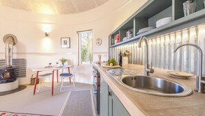 Een moderne keuken met een inbouwfornuis, een spoelbak en een eethoek met een tafel en stoelen.