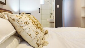 A hotel room with a bed, a bedside table, a mirror, and a bathroom visible through an open door. - 2 bedroom accommodation in Seaview (Seaview)