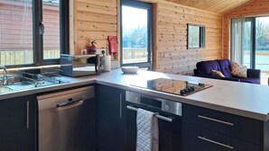 Una cocina moderna con horno empotrado, un lavamanos y una estufa. Se ve una ventana con vistas al exterior.