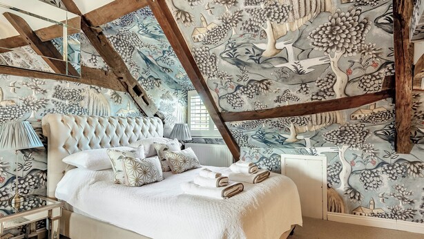 Una camera da letto con un letto grande, un comodino e uno specchio.